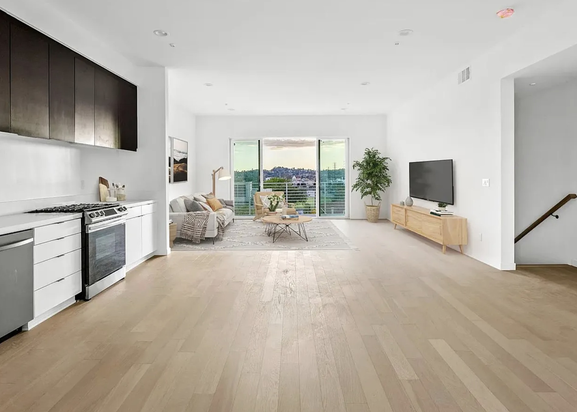 Living room opening to a private balcony with hillside and downtown views